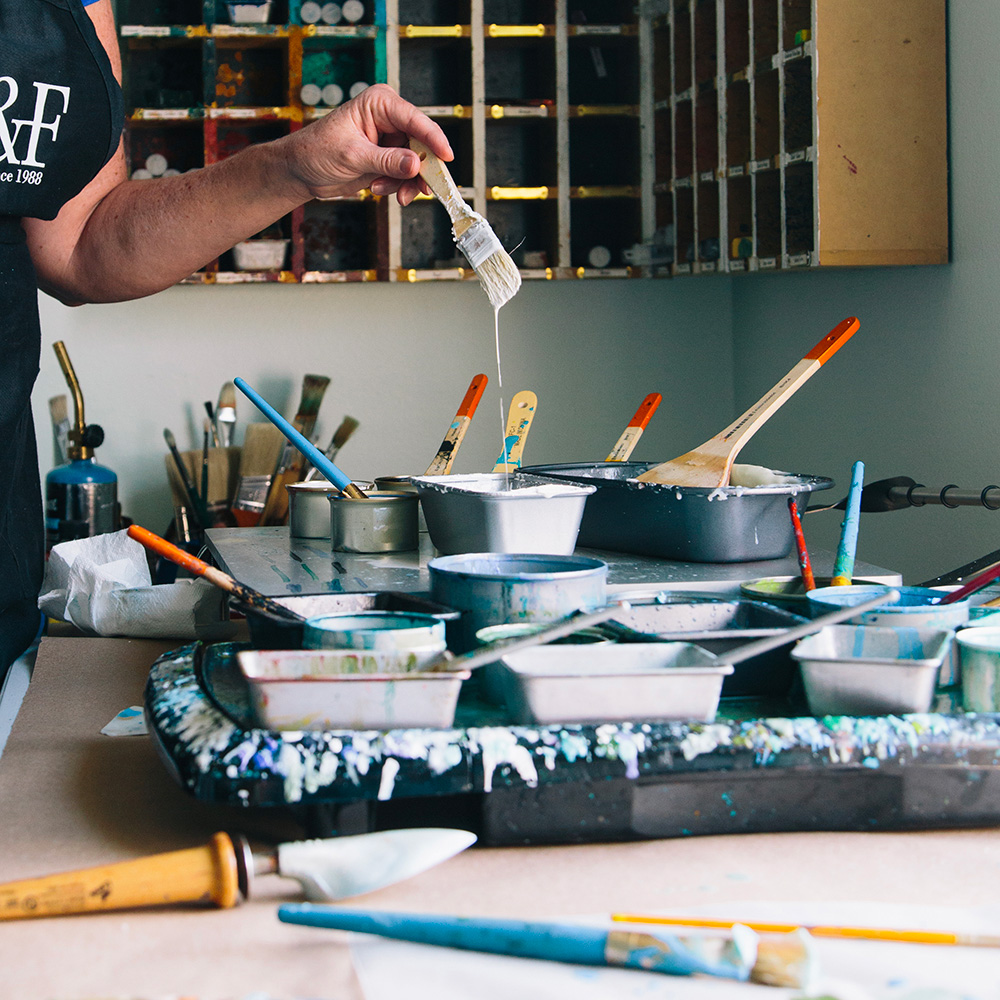 woman holding paint brush dripping into a bowl